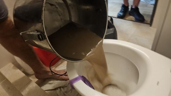 Apă murdară extrasă din canapea după curățare profesională tapițerie în Oradea realizată de CleanSpot prin injecție-extracție și igienizare în profunzime.