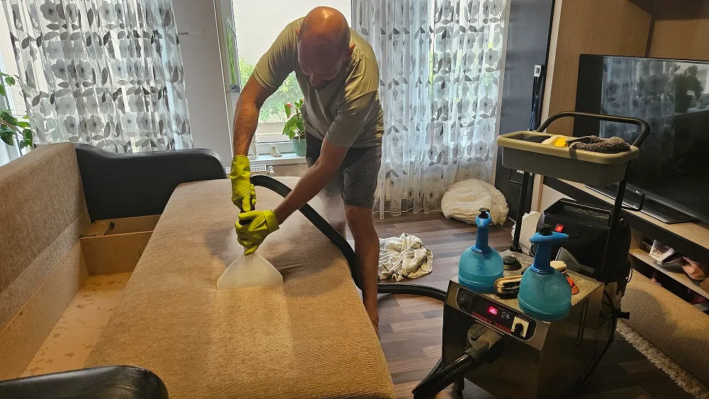 Tehnician Clean Spot efectuează curățarea unei canapele textile prin metoda profesională de injecție-extracție într-o locuință din Oradea.