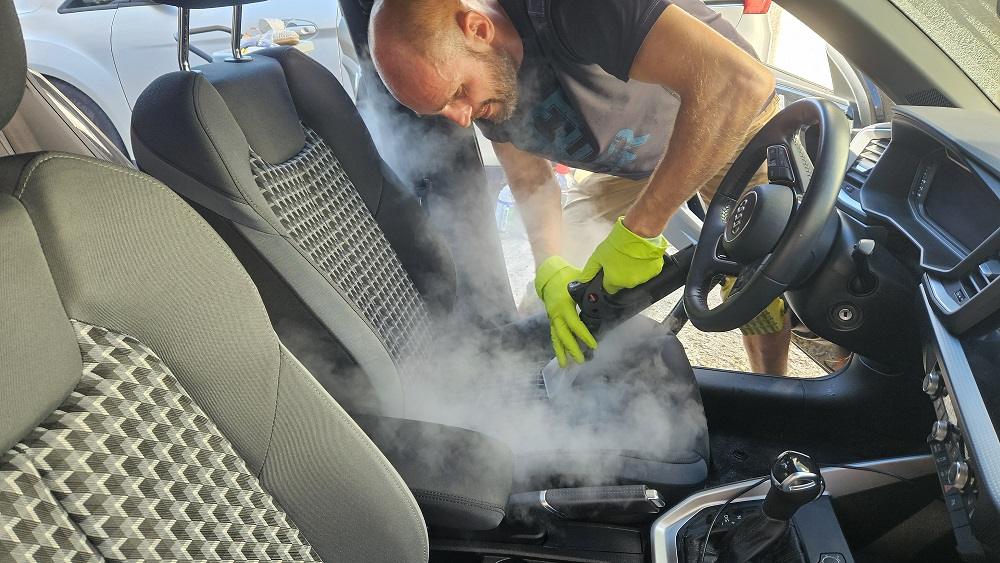 Specialist Clean-Spot igienizând un scaun auto textil cu abur în Oradea