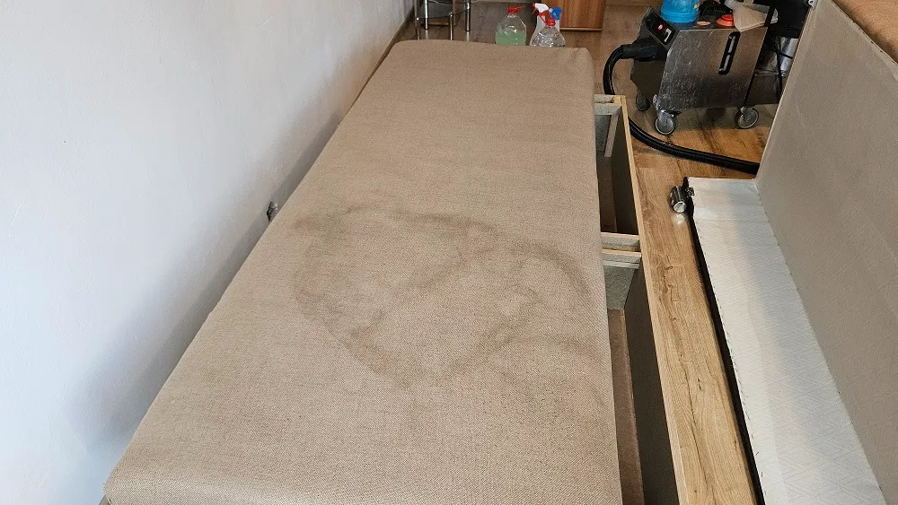 Pete și urme de utilizare pe spătarul unei canapele extensibile