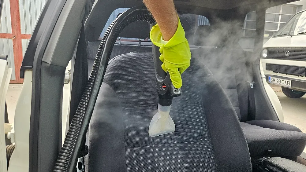 Tehnician folosind extractor profesional pe bancheta auto