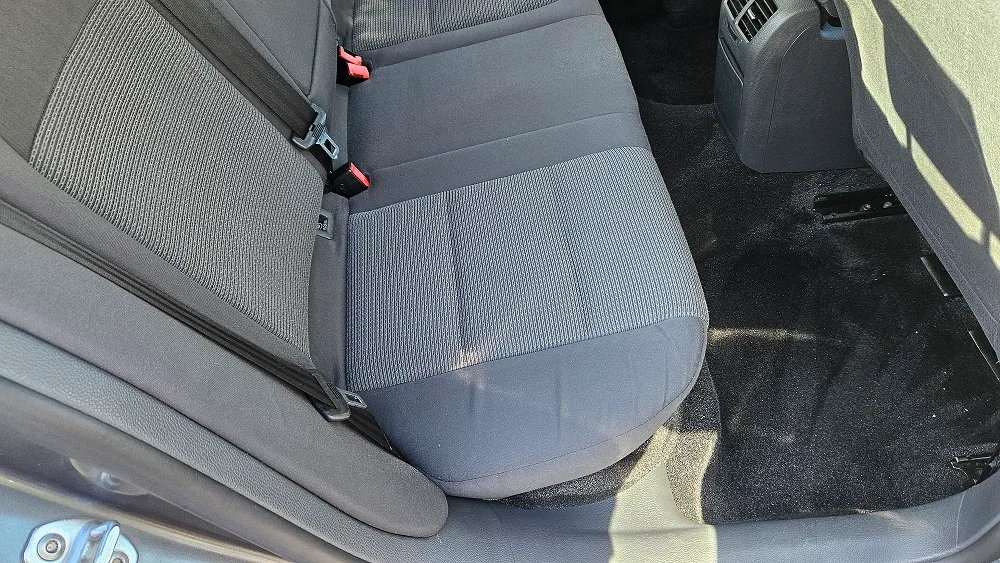 Banchetă spate gri văzută din lateral după curățare, împreună cu podeaua din habitaclu.