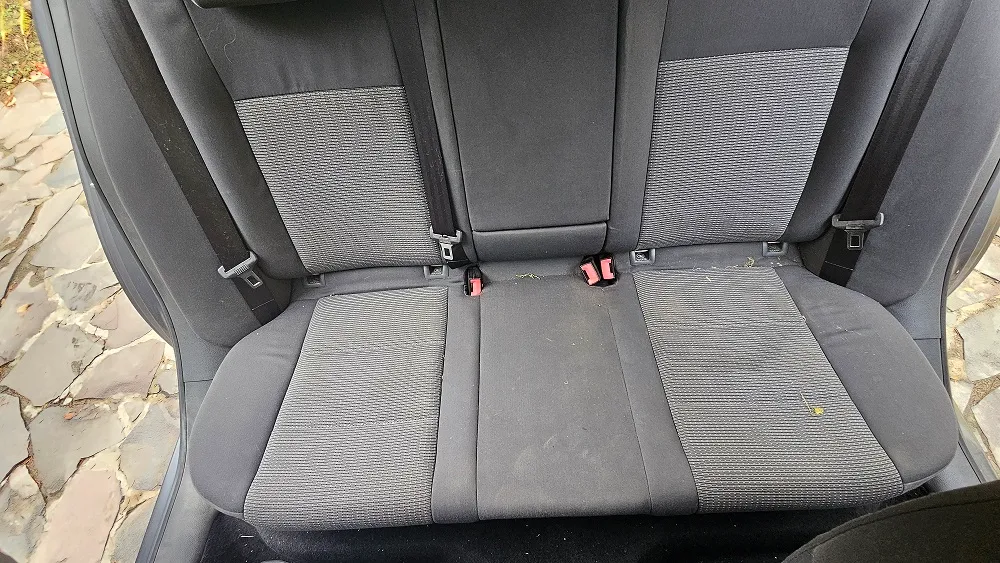 Banchetă auto gri, cu spătar și șezut textil, văzută frontal înainte de curățare.