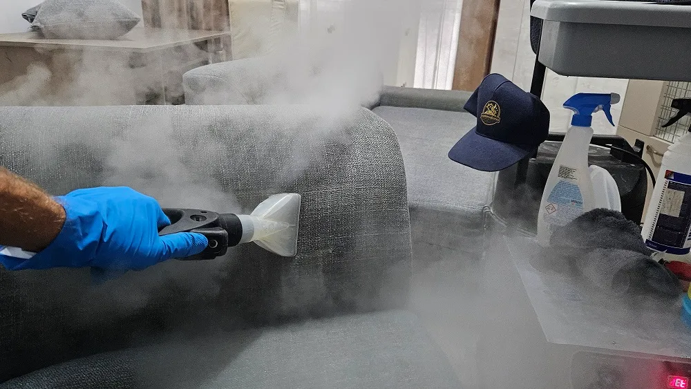 Instrument de lucru și abur vizibil deasupra tapițeriei unui colțar gri